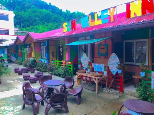 a group of chairs and tables outside of a building at Mama Hostel & Guest House in El Nido