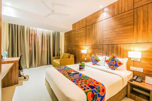 um quarto de hotel com uma cama e uma cadeira em FabHotel RK International em Mumbai