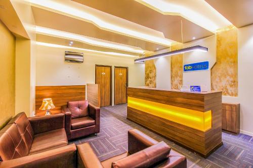 a waiting room with leather chairs and a bar at FabHotel RK International in Mumbai