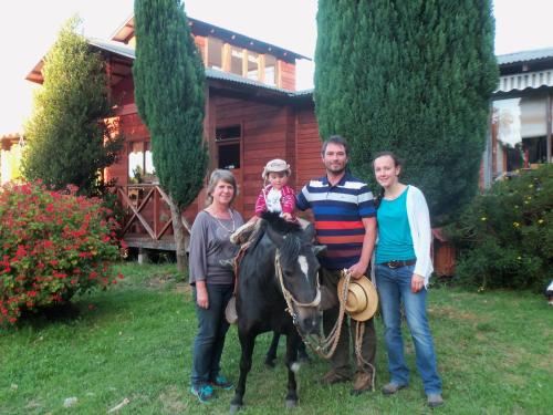 a family posing with a horse in front of a house at Parque Ilihue in Lago Ranco
