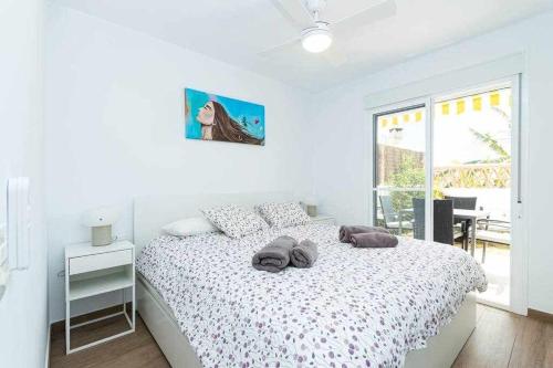 ein weißes Schlafzimmer mit einem Bett und einem Fenster in der Unterkunft Casablanca 4 Apartamento con jardín privado in Fuengirola