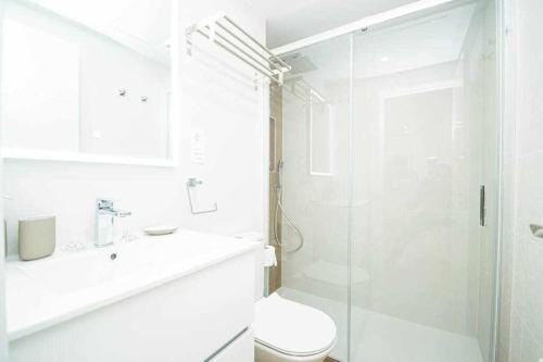 ein weißes Bad mit einer Dusche und einem WC in der Unterkunft Casablanca 4 Apartamento con jardín privado in Fuengirola