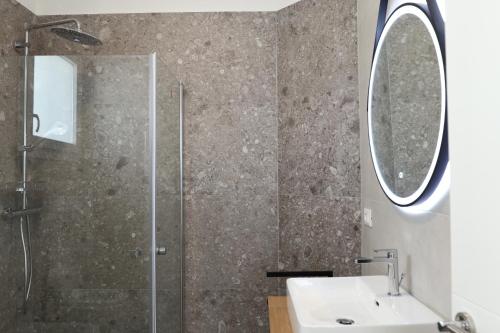 La salle de bains est pourvue d'une douche, d'un lavabo et d'un miroir. dans l'établissement Residence TRE LEONI, à Caorle