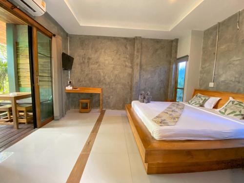 Un dormitorio con una cama y una mesa. en Villa Varich en Chumphon