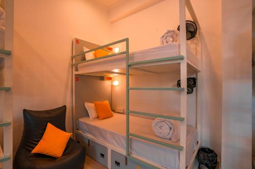 a small room with a bunk bed and a chair at Zostel Rishikesh, Laxman Jhula in Rishīkesh