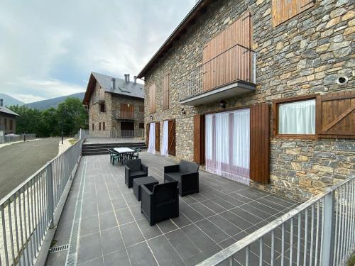 a balcony with benches and a stone building at D01 CABIROL DURRO by IMMOVALL in Durro