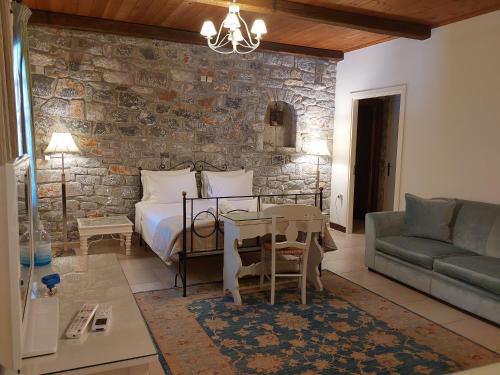 een slaapkamer met een bed en een stenen muur bij Porto Vitilo Boutique Hotel in Karavostasion