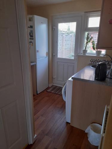 uma cozinha com um frigorífico branco e uma bancada em Private Guest Suite em Telscombe
