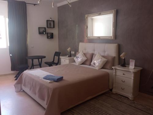 a bedroom with a bed and a table and a window at Agréable appartement in Rabat