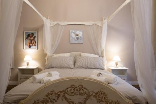 ローマにあるMagnolia St.Peter's Suitesのベッドルーム1室(天蓋付きベッド1台、ランプ2つ付)