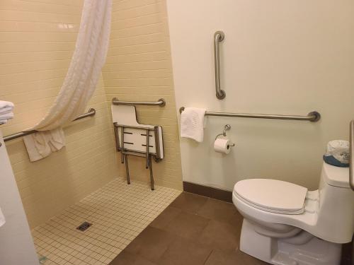 a small bathroom with a toilet and towels at Candlewood Suites Sidney, an IHG Hotel in Sidney