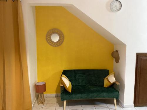 een woonkamer met een groene bank en een gele muur bij Studio avec vue sur la mer piscine partagee et terrasse amenagee a Le Marin a 3 km de la plage in Le Marin