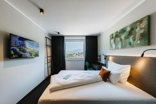 um quarto de hotel com uma cama e uma janela em NIGHT INN Hotel Bahnhofcity Feldkirch em Feldkirch