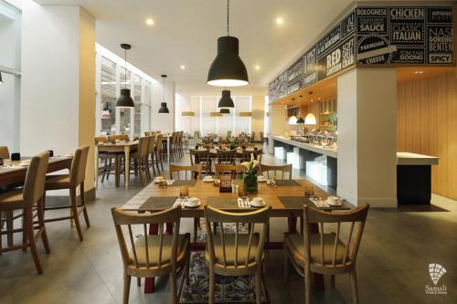 a dining room with tables and chairs and a restaurant at d'primahotel Tangerang in Tangerang