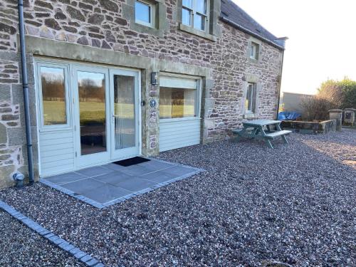 a stone house with a door and a picnic table at The Granary in Stirling