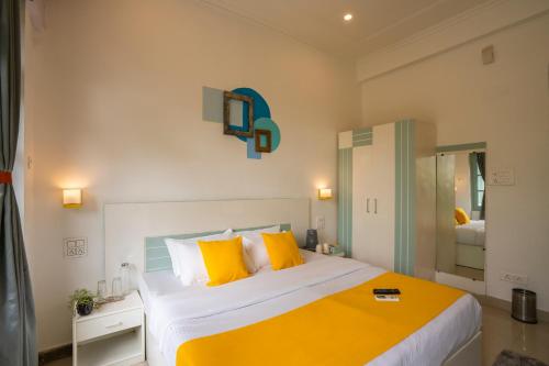 a bedroom with a large bed with yellow pillows at Zostel Rishikesh, Laxman Jhula in Rishīkesh
