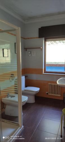 baño con aseo y lavabo y ventana en CASA RURAL ABLANO CUDILLERO en PLAYA CONCHA ARTEDO, en Lamuño