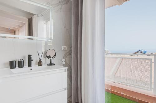 een badkamer met een wastafel en een raam bij Elite Luxury Sunset in Puerto de Santiago