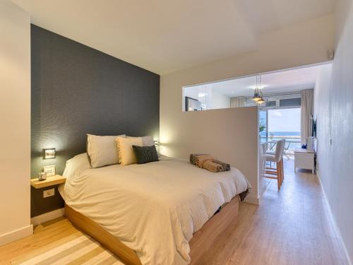 een slaapkamer met een groot bed met een grijze muur bij Marsin Canteras in Las Palmas de Gran Canaria