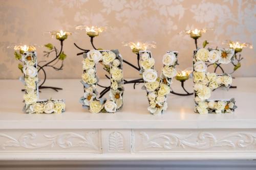 a white table with white flowers and candles at Enchanted Manor in Niton
