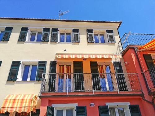 a tall building with a balcony on a street at Case Vacanze Borgo Faraldi in Villa Faraldi