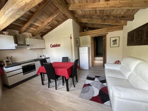 cocina y sala de estar con mesa roja y sillas en profumo di legno, en Aosta