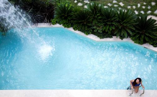 a woman standing in front of a swimming pool with a waterfall at Radisson Blu Hotel & Spa, Istanbul Tuzla in Istanbul