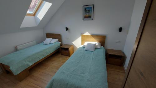 a small room with two beds and a window at Apartamenty Baltic Korona B19 in Darłowo