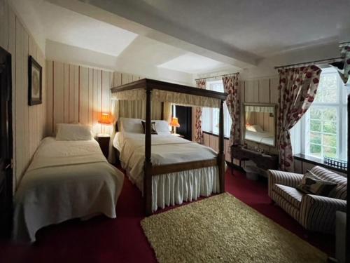 a hotel room with two beds and a mirror at Barton Hall Country House in Pooley Bridge