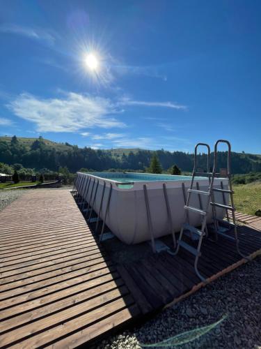 a boat sitting on a dock next to a pool at Карпатська Криївка in Yasinya