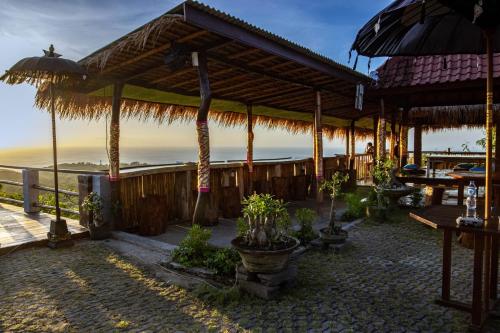 a restaurant with a view of the ocean at The Pande Hill Homestay in Uluwatu
