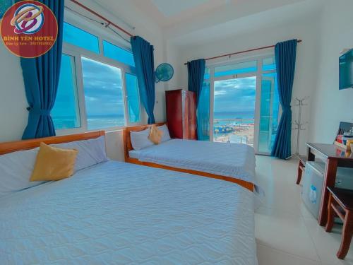 a bedroom with two beds with a view of the ocean at Binh Yen Hotel in Ly Son