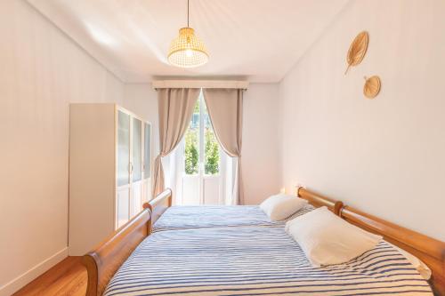 łóżko w pokoju z oknem w obiekcie EKI ETXEA Piso en Orio para 6 personas al lado de San Sebastián PARKING w mieście Orio