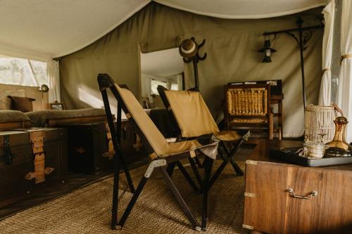 una habitación con una silla y una mesa en una tienda de campaña en Serengeti Pioneer Camp, en Mugumu