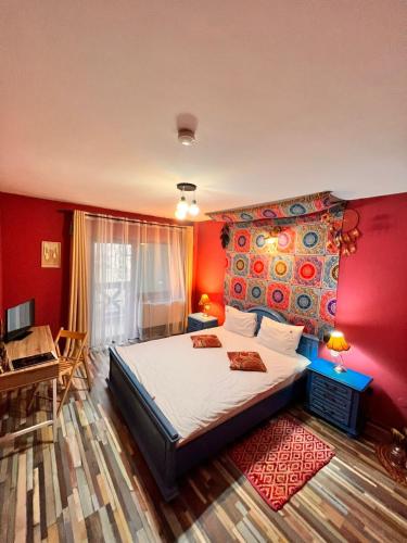ein Schlafzimmer mit einem großen Bett und einer roten Wand in der Unterkunft Vila Alsace Podu' cu Lanturi in Bacău