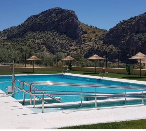 a large swimming pool with mountains in the background at Casa Alameda in Benarrabá