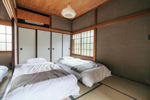 a room with two beds in it with windows at mysa hakone in Hakone