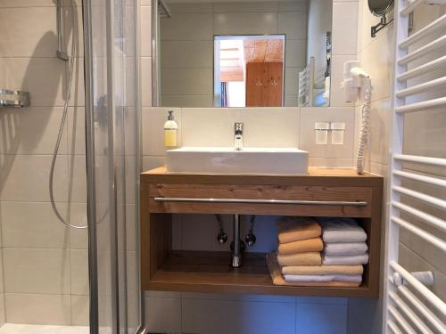 ein Bad mit einem Waschbecken und einem Spiegel in der Unterkunft Saffretta Ferienwohnungen in Ischgl