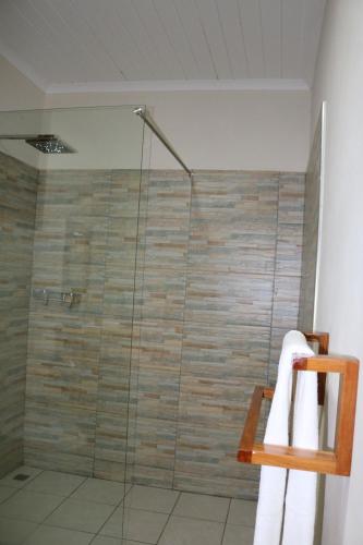 a bathroom with a shower with a glass door at Pescador Villas in Inhambane