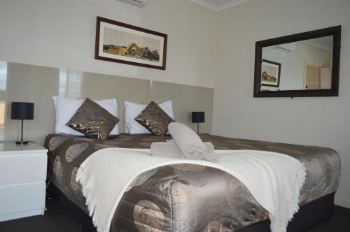 a bedroom with a large bed and a mirror at Blue Lake Motel in Mount Gambier