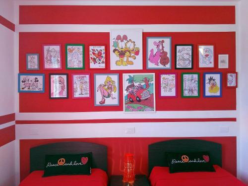 a room with two red beds and pictures on a wall at Case Vacanze Borgo Faraldi in Villa Faraldi
