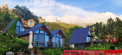 a house with blue windows and a mountain at Ban Mai Xanh homestay Tam Đảo in Vĩnh Phúc