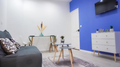 sala de estar con sofá y pared azul en AppartCosy-StQuentin, en Saint-Quentin