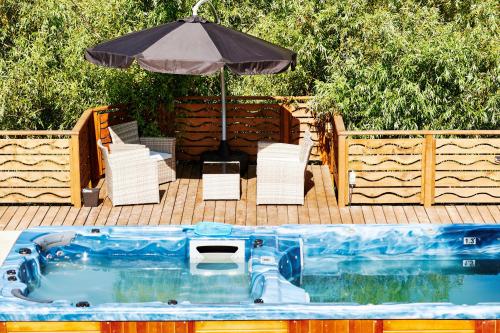 a swimming pool with an umbrella and chairs and a table at Casa Chilia Resort&Spa in Chilia Veche