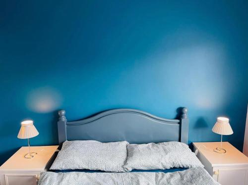 a blue bedroom with a bed with two night stands at Mia Property in Bristol