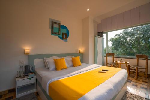 a bedroom with a large bed with yellow pillows at Zostel Rishikesh, Laxman Jhula in Rishīkesh
