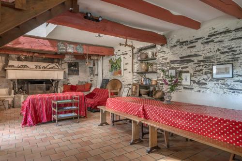 un salon avec des tables et un mur en briques dans l'établissement Gîte typique pour 6 à Rochefort-en-terre, à Rochefort-en-Terre