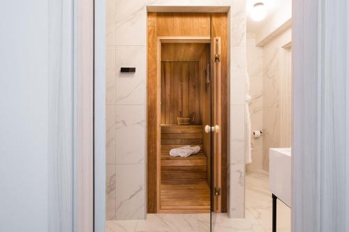a bathroom with a shower with a wooden door at Luxury villas on Island Pag - Plant Villas Novalja in Novalja