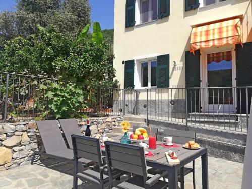 a table and chairs on a patio in front of a house at Case Vacanze Borgo Faraldi in Villa Faraldi