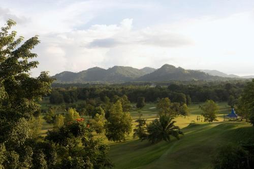 a view of a golf course with mountains in the background at Novotel Bangka Hotel & Convention Center in Pangkalpinang